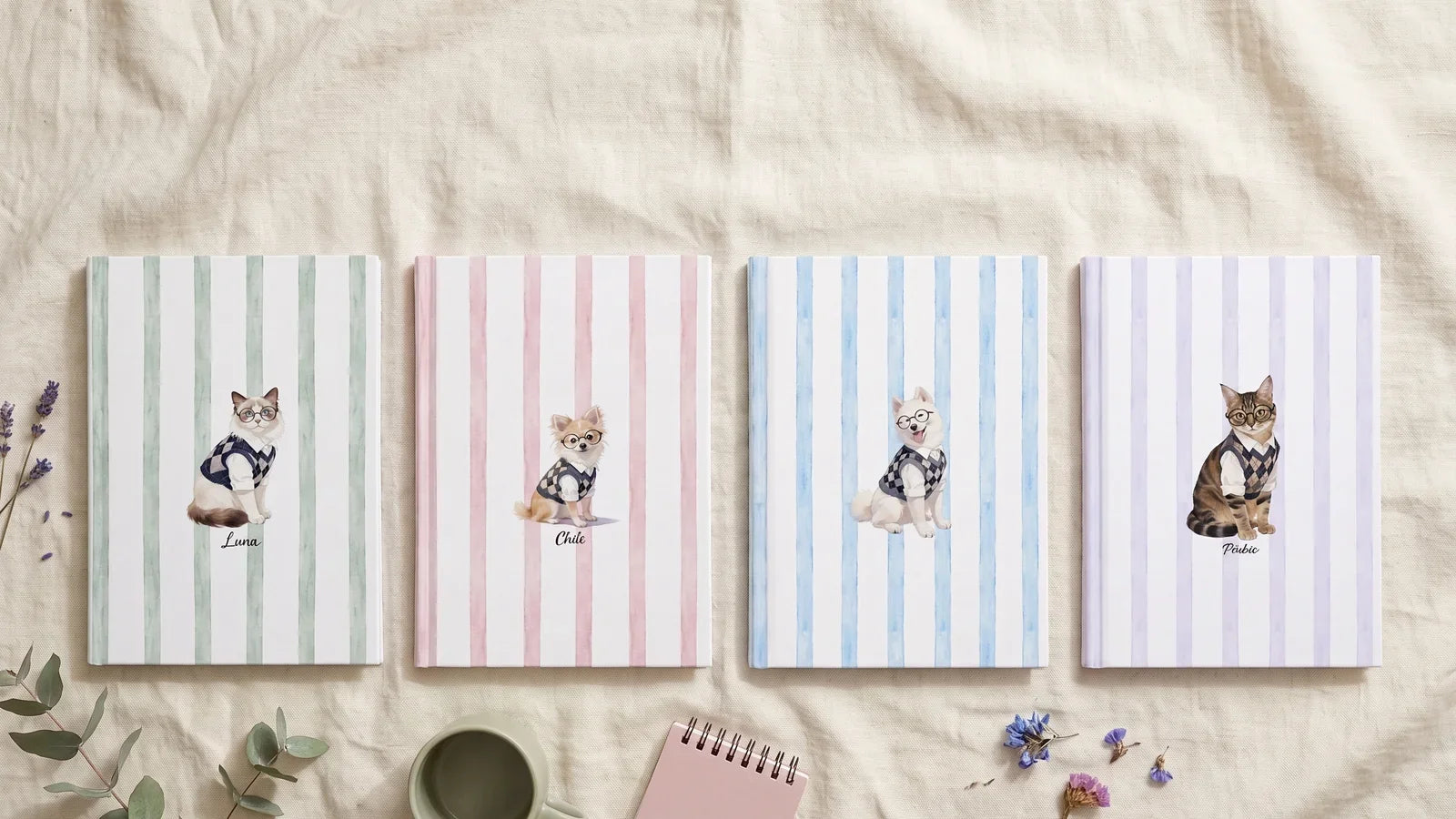 Four striped watercolor pet notebooks in sage, dusty pink, french blue and lavender laid out on linen