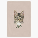 Colored pencil portrait of a tabby cat printed on a dusty pink fleece blanket, with the name "Milo" drawn below.