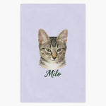 Colored pencil portrait of a tabby cat printed on a lavender fleece blanket, with the name "Milo" drawn below.