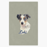 Colored pencil portrait of a blue merle Australian shepherd puppy printed on a sage fleece blanket, with the name "Loki" drawn below.