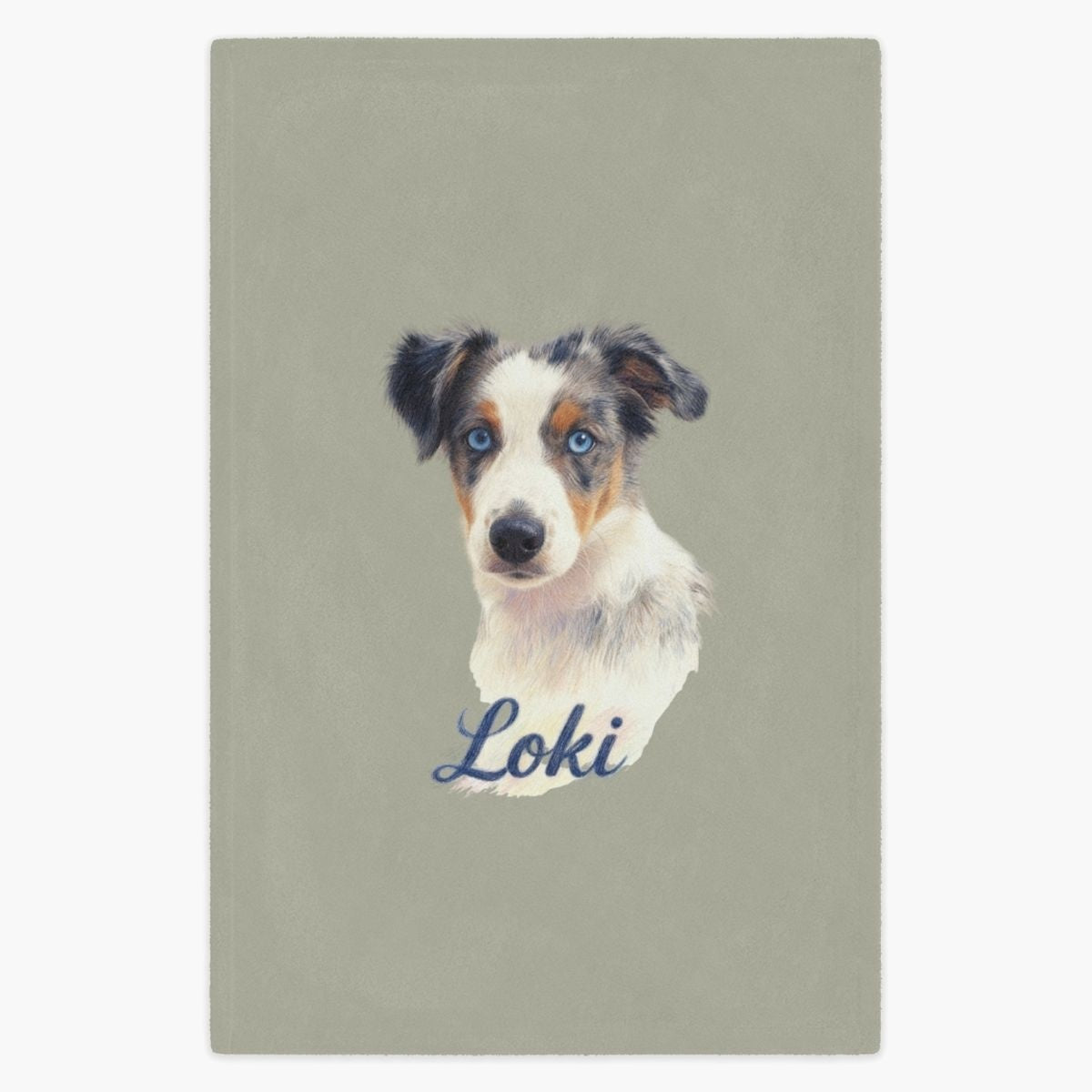 Colored pencil portrait of a blue merle Australian shepherd puppy printed on a sage fleece blanket, with the name "Loki" drawn below.