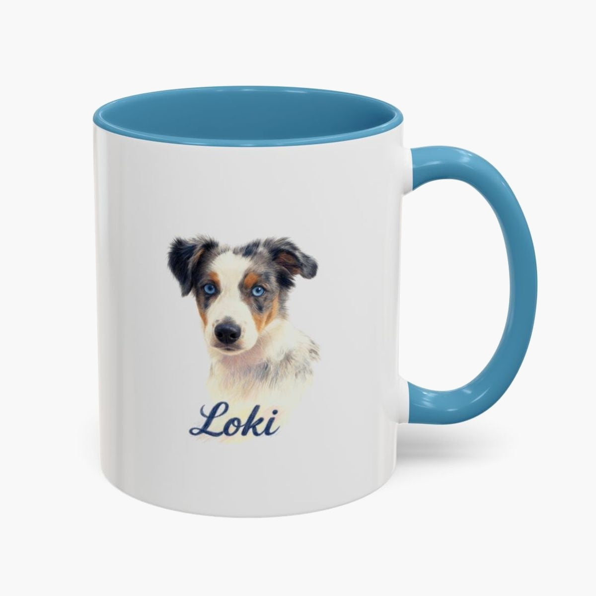 Colored pencil portrait of a blue merle Australian shepherd puppy on a 11 oz mug with a light blue handle, with the name "Loki" drawn below.