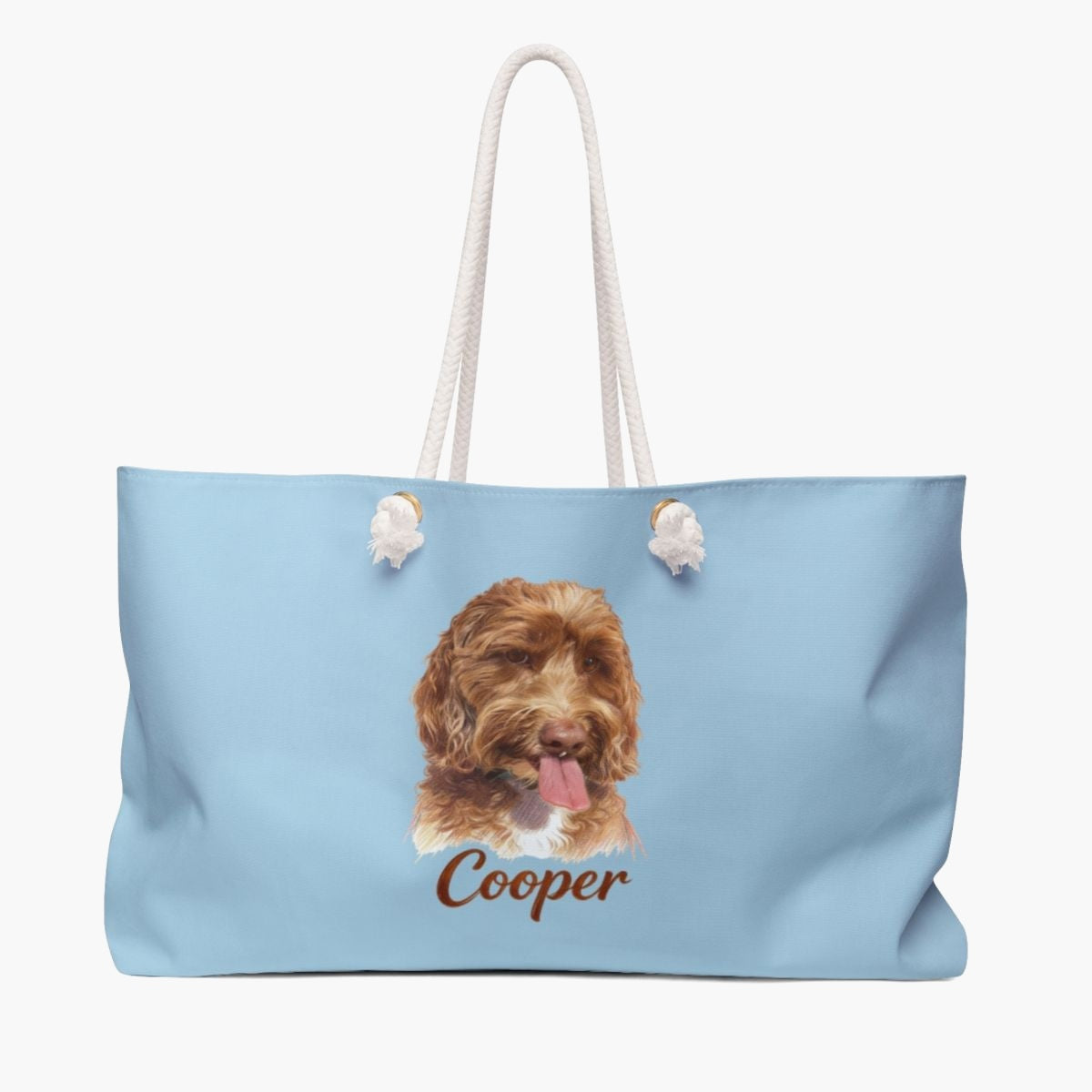 Colored pencil portrait of an apricot labradoodle on a french blue weekender bag with white rope handles, with the name "Cooper" drawn below.