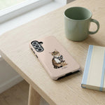Student Watercolor Pet Phone Case. The phone case lying flat on a pale oak desk beside a sage ceramic mug and a small notebook.