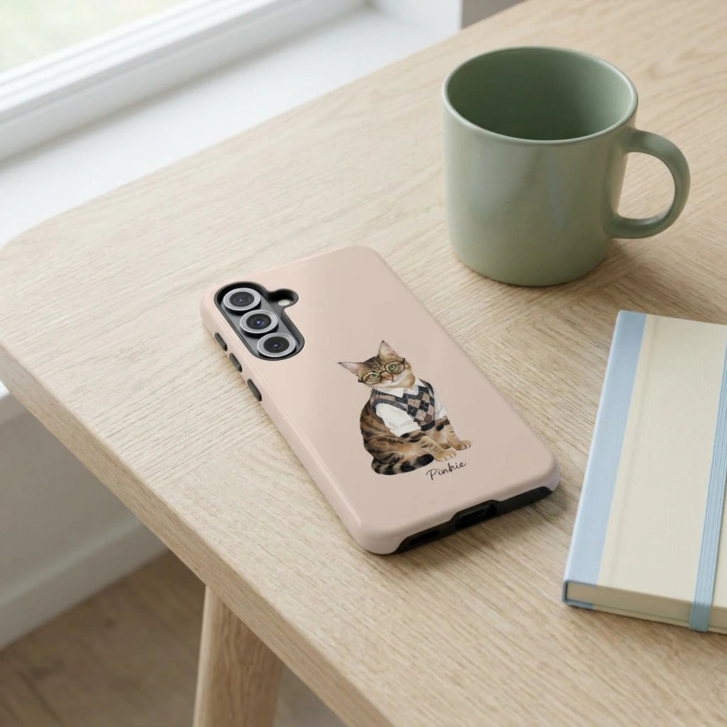 Student Watercolor Pet Phone Case. The phone case lying flat on a pale oak desk beside a sage ceramic mug and a small notebook.