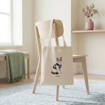 Student Watercolor Pet Tote Bag. The natural canvas tote bag slung over the back of a pale wooden chair in a bright minimal room.